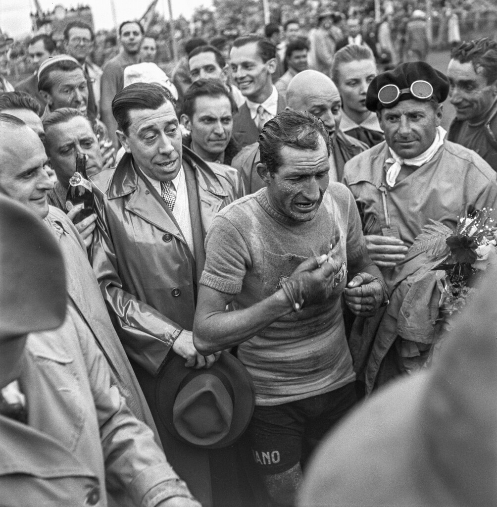 Der legendäre Italiener Gino Bartali gewinnt die 15. Etappe der Tour de France. Am Zielort in Lausanne wird er und die andern Fahrer vom französischen Schauspieler Fernandel (links neben Bartali) begrüsst. (Foto: Keystone/Photopress-Archiv/Str)