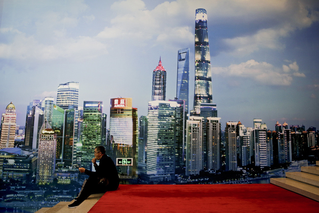 Ein Museumsbesucher macht Pause vor dem Bild des Financial District Shanghais, das in der Ausstellung zum 40. Jahrestag der Öffnung und Reform Chinas im Pekinger Nationalmuseum gezeigt wird. (Keystone/AP, Andy Wong)