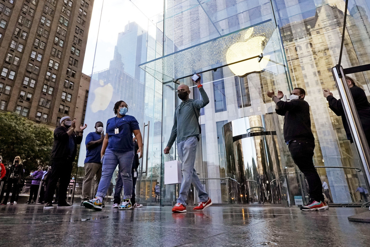 Der erste Kunde am ersten Verkaufstag hält vor dem Apple Flagship Store an der Fifth Avenue in New York triumphierend sein iPhone 13 in die Höhe. (Bild vom 24. September 2021, Keystone/AP Photo, Richard Drew)