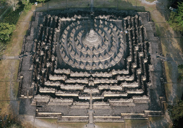 Der Borobudor auf der Indonesischen Insel Java
Der Borobudur ist weltweit ein Nonplusultra sakraler Baukunst: eine Stufenpyramide von 113 m Sockelbreite und 35 m Höhe mit fünf quadratischen und drei runden Terrassen, mit einem Bilderfries von 2,5 km Länge und über 400 Buddhafiguren. 1300 Reliefpaneele, die aus dem Leben der Bodhisattvas und des Buddha erzählen, verdeutlichen dem Pilger den Aufstieg aus der „Welt der Lüste“ durch „die Welt der Namen und Formen“ zu der erstrebten Läuterung. Der Stupa bildet…