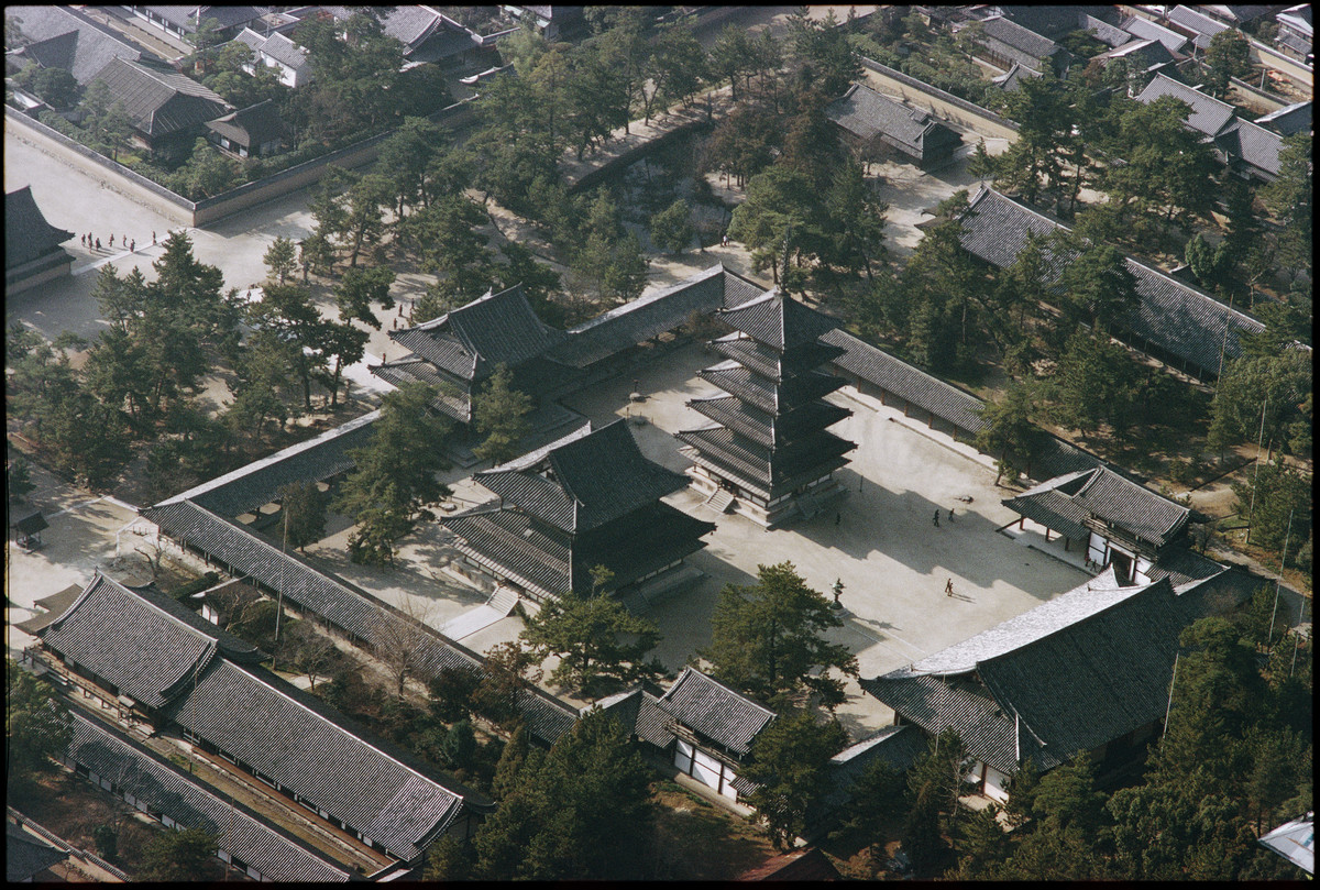  Der Tempelbezirk des Horyu-ji bei Nara, Hauptsitz der budhistischen Shotoku-Sekte, enthält die ältesten Holzbauten Japans und der Welt.

Das Flugbild zeigt den von einem überdachten Wandelgang umgebenen Tempelhof des Westbezirks, mit der fünfstöckigen Pagode (erbaut 607) und der Goldenen Halle (Kondo). Die Tempelanlagen bei und in Nara, unvergleichliche Zeugnisse asiatischer Sakralarchitektur und ein Nonplusultra des Holzbaus, zogen mit erstaunlicher Verspätung ins Pantheon des Welterbes ein: der Horyu-…