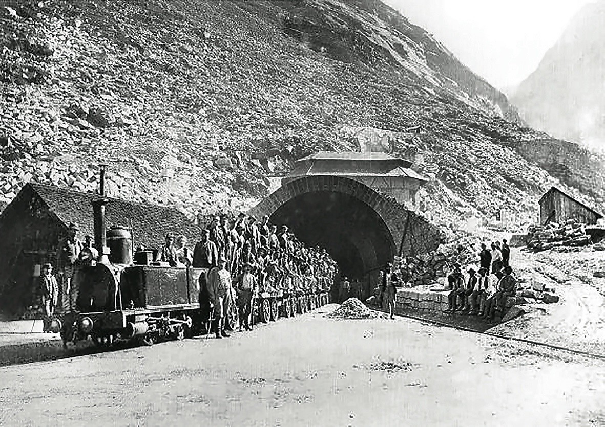 Der erste mit triumphierenden Arbeitern aus Airolo besetzte Zug trifft in Göschenen ein.