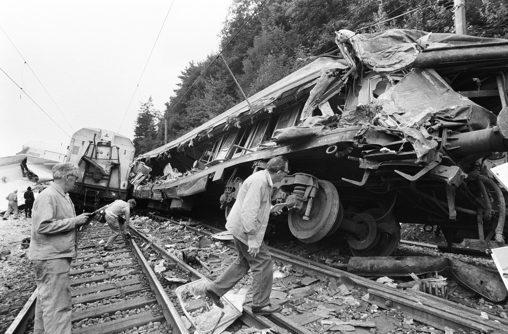 1982: Ein Güterzug rammt am frühen Morgen in der Nähe von Othmarsingern im Kanton Aargau einen Schnellzug, der von Dortmund über Basel nach Rimini unterwegs war. Sieben Wagen des Personenzuges wurden aus den Schienen geworfen, zwei davon wurden völlig aufgeschlitzt. Sechs Menschen sterben, hundert werden verletzt. (Foto: Keystone/Str)