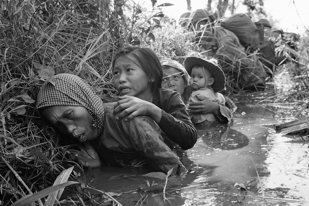 Südvietnamesische Frauen suchen in einem verschlammten Kanal 25 Kilometer westlich von Saigon Schutz vor einem Angriff des Vietcong. (Foto: AP/Horst Faas)
