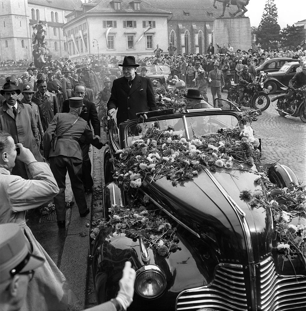 1946: «Let Europe arise»: Im offenen Wagen fährt Winston Churchill durch Zürich. In den Strassen wird er von der Bevölkerung begeistert empfangen. Auf dem Münsterhof richtet er sich an Zehntausende. Dann, in der Aula der Universität Zürich hält Churchill seine berühmte Europa-Rede. "Unser beständiges Ziel muss sein, die Vereinten Nationen aufzubauen und zu festigen. Unter- und innerhalb dieser weltumfassenden Konzeption müssen wir die europäische Völkerfamilie in einer regionalen Organisation neu zusammenf…