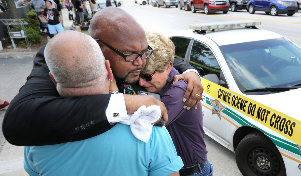 Im Nightclub "Pulse" eröffnet der 29-jährige Amerikaner Omar Siddiqui Mateen um zwei Uhr das Feuer auf die 300 Gäste im Lokal. 49 Menschen sterben. 53 Menschen werden teils schwer verletzt. Der Täter nimmt Geiseln und wird nach drei Stunden von der Polizei erschossen. Als Motiv werden einerseits ein Hass auf Homosexuelle und anderseits Inspirationen durch den "Islamischen Staat" angegeben. Im Bild: Orlandos Pfarrer Kelvin Cobaris (Mitte) tröstet Orlandos Stadtkommissarin Patty Sheehan und Terry DeCarlo, ei…