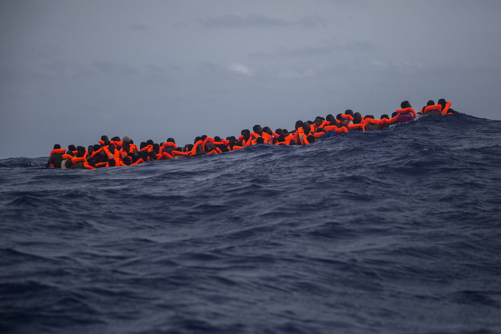 Sub saharan migrants wait to be rescued by aid workers of Spanish NGO Proactiva Open Arms in the Mediterranean Sea, about 15 miles north of Sabratha, Libya on Tuesday, July 25, 2017. More than 120 migrants were rescued Tuesday from the Mediterranean Sea while 13 more "including pregnant women and children" died in a crammed rubber raft, according to a Spanish rescue group. (AP Photo/Santi Palacios)