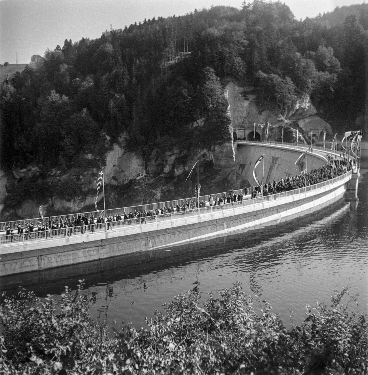 Im Kanton Freiburg wird der Lac de la Gruyère (Greyerzersee) eingeweiht. Mit einer Länge von 13,5 Kilometer ist er der längste Stausee in der Schweiz. Im See liegt das Inselchen Île d’Ogoz. Das Bild zeigt die Einweihung der Staumauer bei Rossens. (Foto: Keystone/Photopress-Archiv/Walter Studer)