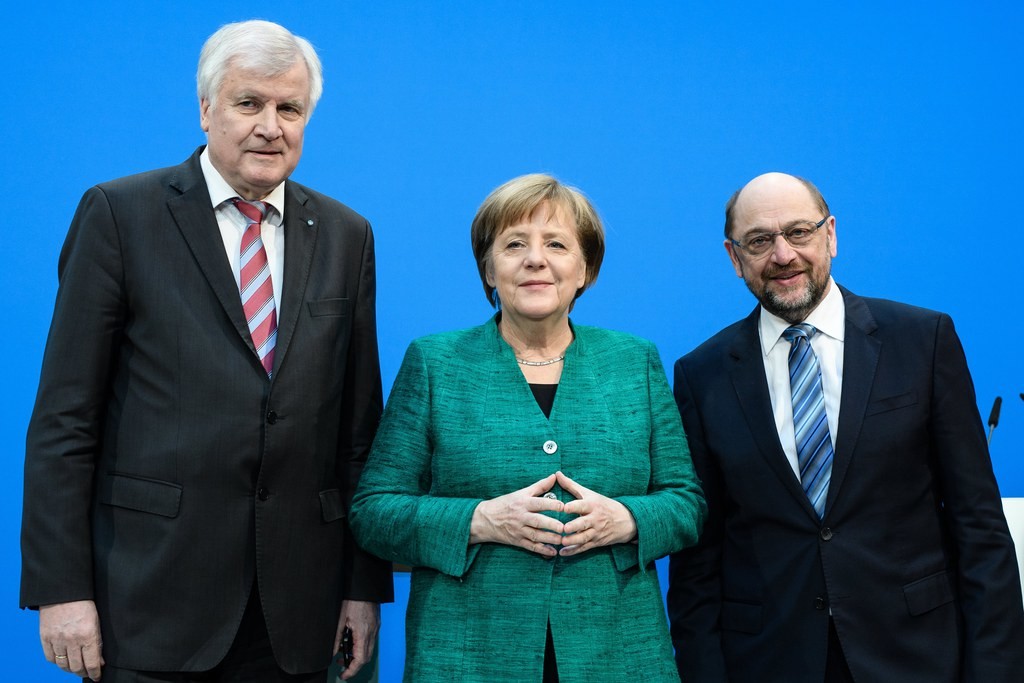 Neuauflage der Grossen Koalition in Deutschland. Bundeskanzlerin Angela Merkel und die SPD von Parteichef Martin Schulz (rechts) einigen sich zusammen mit dem bayerischen Ministerpräsidenten Horst Seehofer (CSU) auf eine Fortführung der Grossen Koalition. Vor allem bei jüngeren SPD-Mitgliedern ist die Allianz sehr umstritten. Der SPD ist gelungen, dem Koalitionsvertrag eine sozialdemokratische Handschrift zu verpassen. Aus diesem Grund rumort es auch bei der CDU. (Foto: Keystone/EPA/Hayoung Jeon)