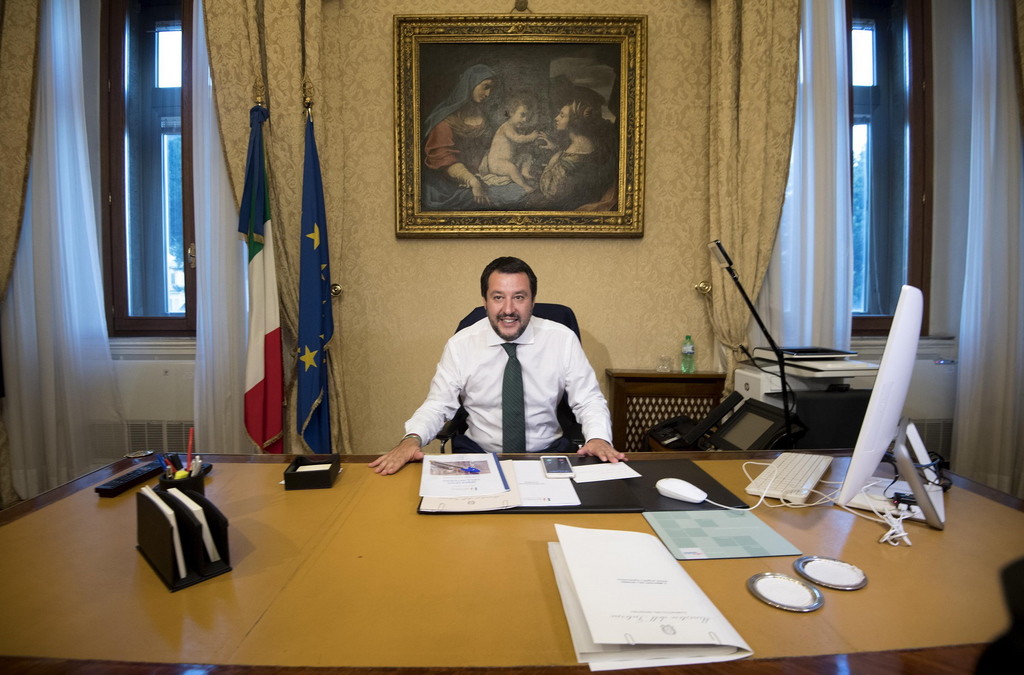 Der Schattenministerpräsident: Matteo Salvini, Chef der rechtspopulistischen Lega, nimmt erstmals in seinem neuen Büro in Rom Platz - vor der Europa-Fahne und der italienischen Flagge. Er ist jetzt Innenminister, Vizeministerpräsident und der neue starke Mann Italiens. (Siehe Artikel unten). (Foto: Keystone/EPA/Claudio Peri)