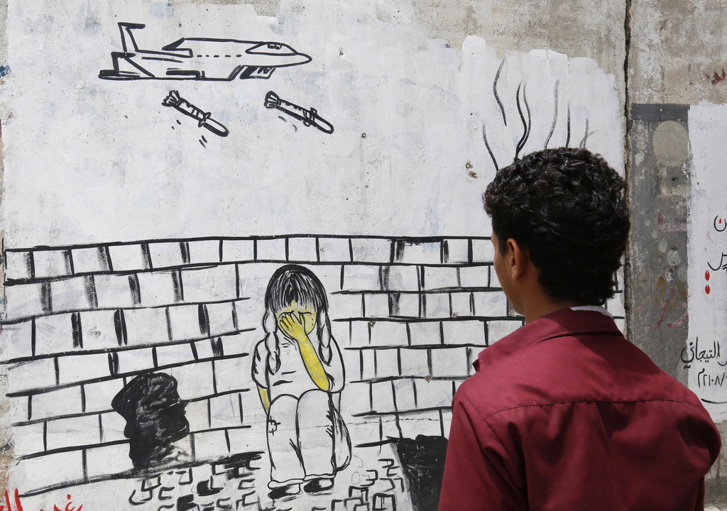 Ein Graffito in der jemenitischen Hauptstadt Sanaa, fotografiert am Freitag. Es wendet sich gegen die saudischen Luftangriffe, die immer wieder zivile Opfer fordern. Am Donnerstag hatten Kampfflugzeuge des von Saudi-Arabien geführten Militärbündnisses einen Markt und einen Schulbus in Saada in Nordjemen bombardiert. Dabei starben nach Angaben der von den Huthis kontrollierten Regierung in Sanaa 51 Menschen, unter ihnen mehr als 40 Schulkinder. 79 wurden verwundet. Das IKRK bestätigte den Angriff. (Foto: Ke…