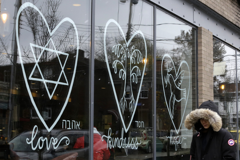 In this Tuesday, Nov. 20, 2018 photo, a woman walks past the window of a Starbucks in the Squirrel Hill neighborhood of Pittsburgh. Itâ€™s barely three weeks after the Tree of Life massacre. And people in, Squirrel Hill neighborhood arenâ€™t shying away from celebrating Thanksgiving. Theyâ€™re welcoming it. As one former Tree of Life rabbi puts it, people in the community both recognize what theyâ€™ve lost and recognize what they have. (AP Photo/Gene J. Puskar)