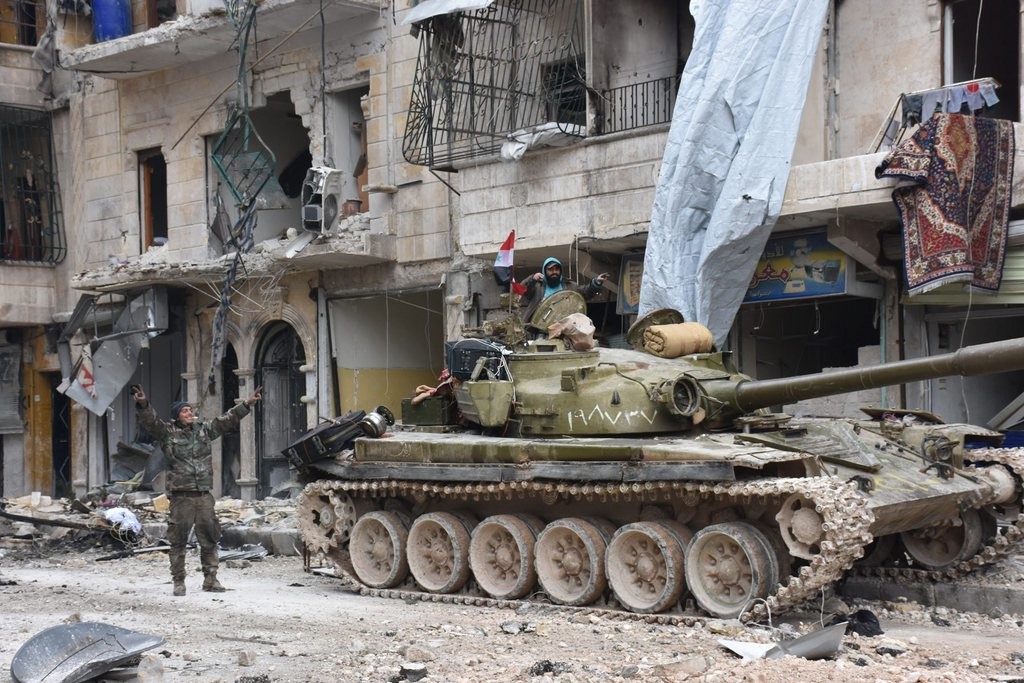 Aleppo nach dem Fall: Jubelnde syrische Soldaten im bis vor kurzem schwer bombardierten Quartier Sukkari im Osten der eroberten nordsyrischen Metropole. Das Bild stammt von der offiziellen syrischen Nachrichtenagentur SANA. (Foto: Keystone/EPA/SANA)

