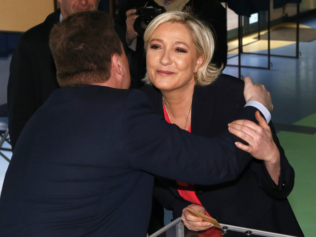 Umarmung und Küsschen vor der Stimmabgabe. Die Rechtsaussen-Kandidatin Marine Le Pen wählt am Sonntagvormittag in Hénin Beaumont in Nordfrankreich. (Foto: Keystone/AP/Michel Spingler)

