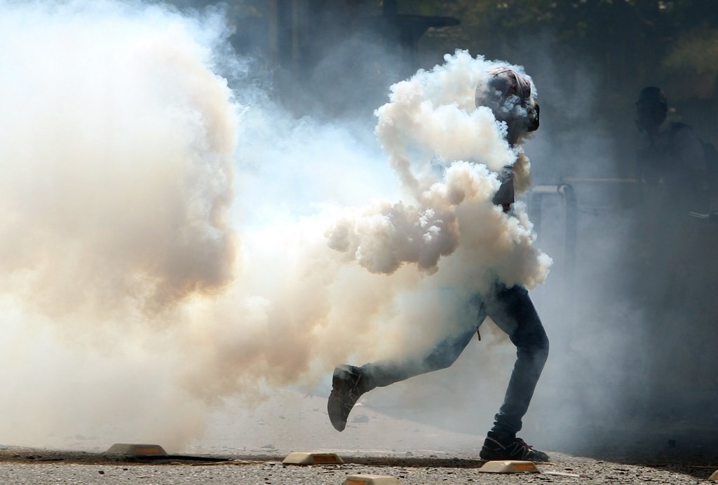 Ein Demonstrant, eingehüllt in Tränengas, am Freitag in Caracas. (Foto: Keystone/EPA/Mauricio Duenas Castenada)