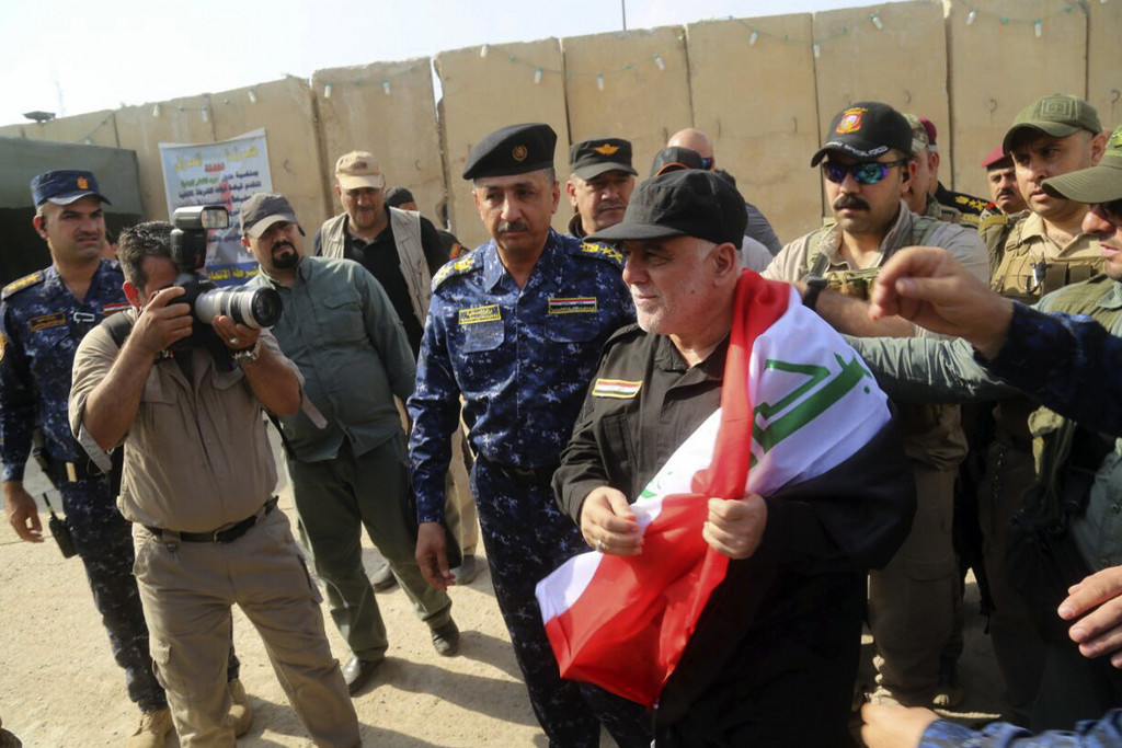 Der irakische Ministerpräsident mit einer irakischen Flagge am Sonntag in Mosul (Foto: Keystone/Iraqi Federal Police Press Office/AP) 