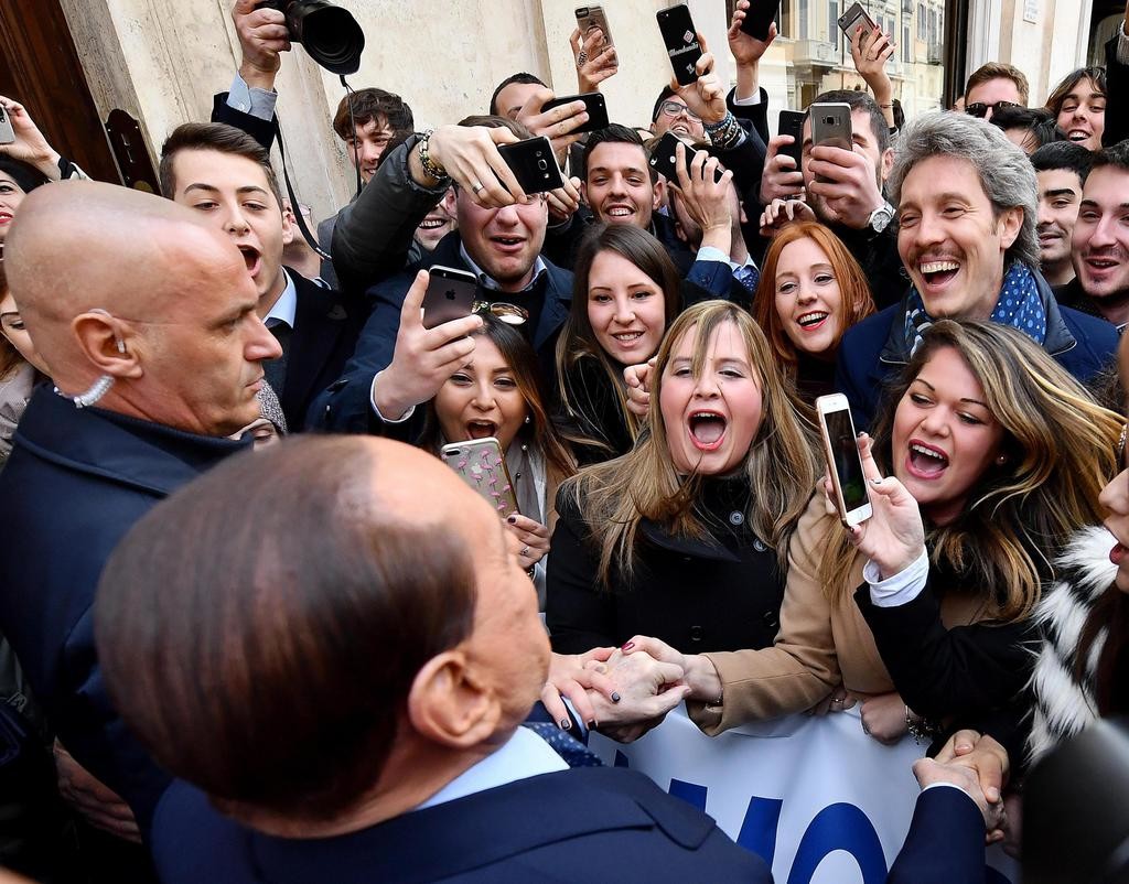 Berlusconi (vorne im Bild) mit jungen Fans in Rom. „Silvio, Silvio“, schreien sie. Berlusconi erklärt ihnen: „Ihr müsst den Wahlzettel nehmen und ein Kreuz bei Forza Italia machen.“ (Foto: Keystone/Ansa/Ettore Ferrari)
