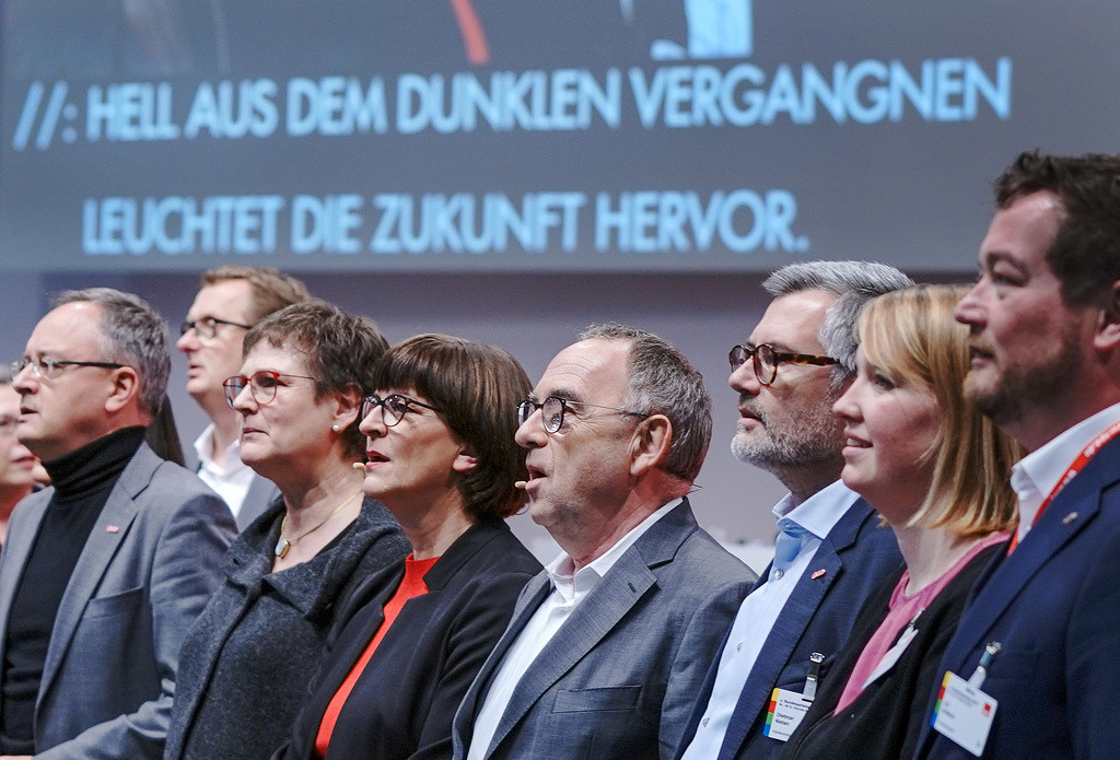 Norbert Walter-Borjans (Vierter von links) und Saskia Esken (Vierte von rechts), die beiden Bundesvorsitzenden der SPD, singen beim SPD-Bundesparteitag das Schlusslied „Brüder, zur Sonne, zur Freiheit“. (Foto: Keystone/DPA/Michael Kappeler)