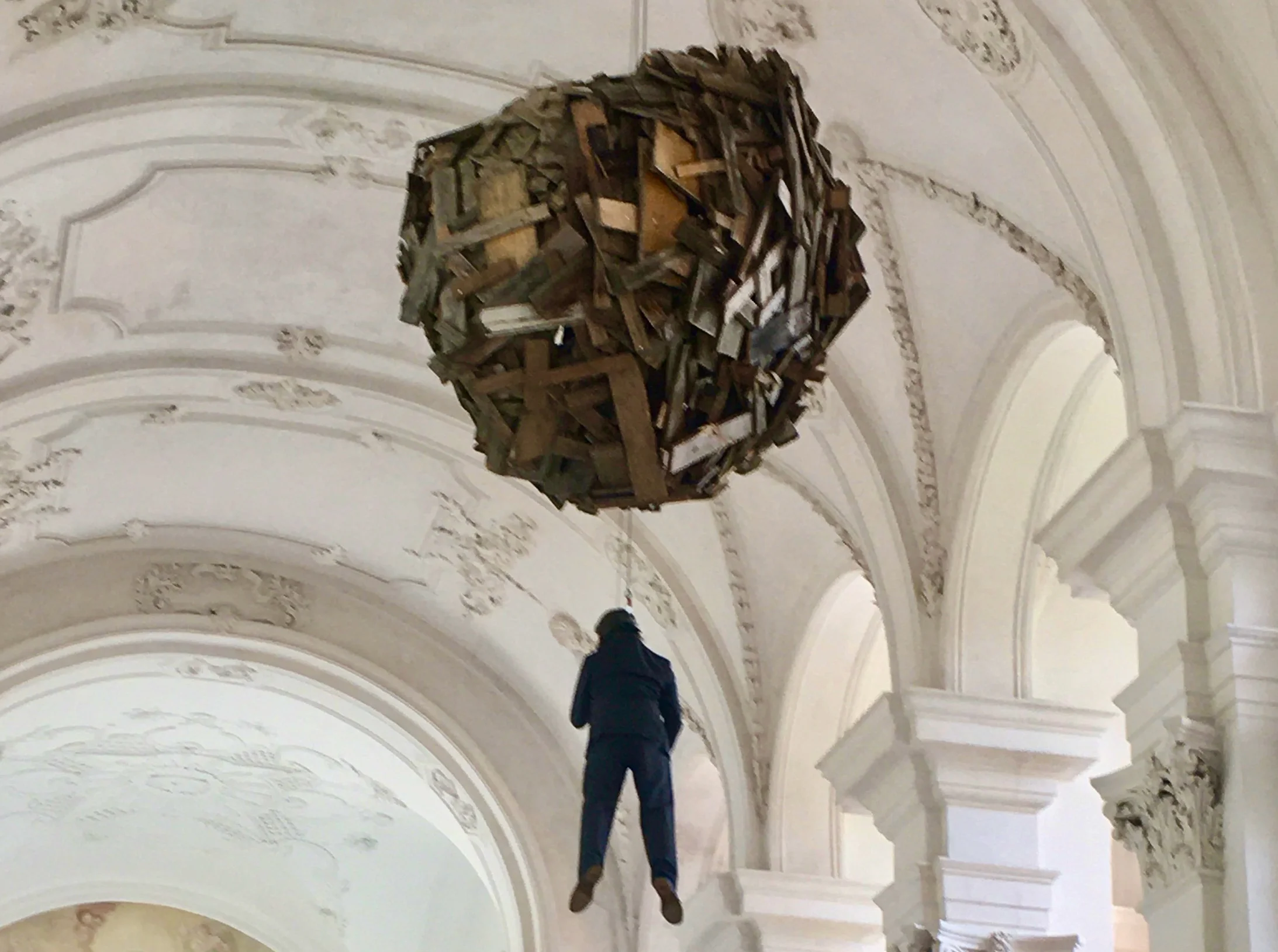 Performance bei der Eröffnung: Christoph Rütimann lässt sich zur Kugel aus Abfallholz hochziehen, in der er sich anschliessend einigeln wird.