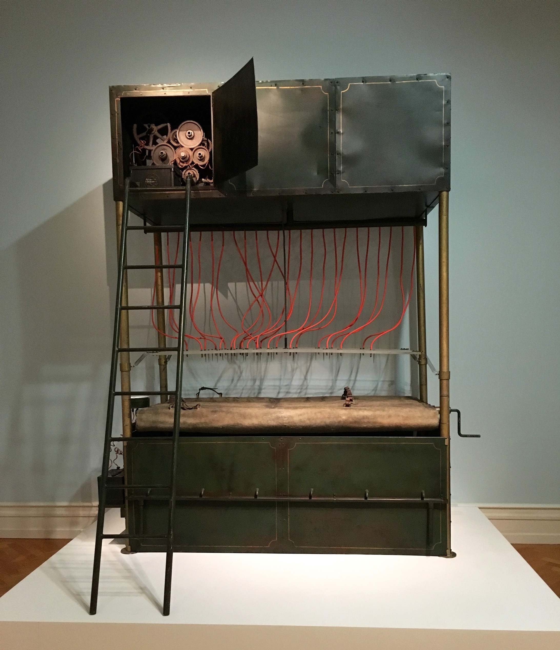 In der Erzählung „Die Strafkolonie“ schildert Franz Kafka eine brutale Hinrichtungsmaschine. 1975 liess Harald Szeemann diese Maschine nachbauen für seine Ausstellung „Junggesellenmaschinen“.