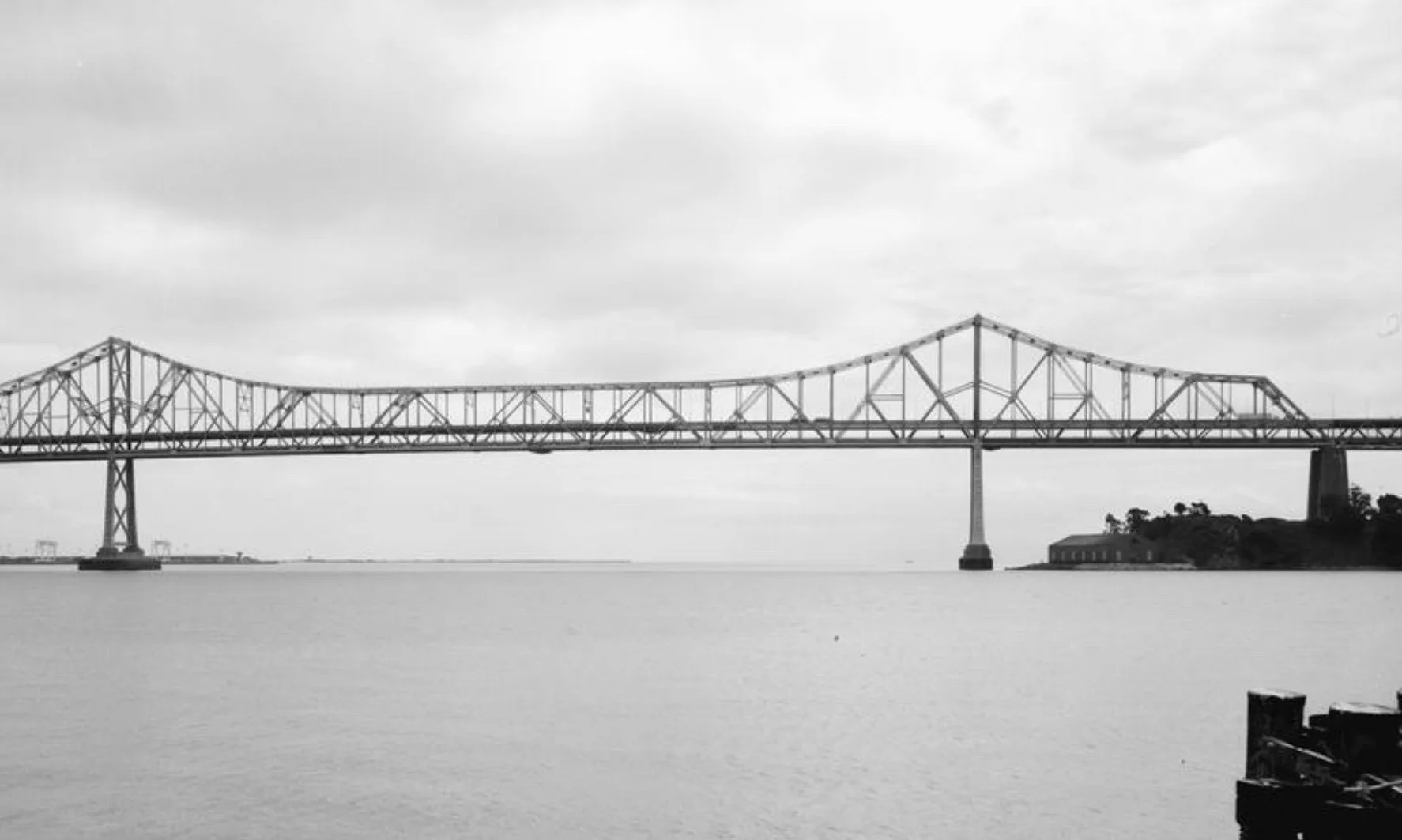Gut sechs Monate vor der Eröffnung der Golden Gate Bridge wird die San Francisco-Oakland Bay Bridge eingeweiht. Die zweistöckige Brücke überspannt die Bucht von San Francisco und verbindet die Städte Oakland und San Francisco. Sie besteht aus zwei Hängebrücken mit je zwei Pylonen. In der Mitte der 7'180 Meter langen Brücke liegt das Inselchen Yerba Buena. Auf dem oberen Deck fahren die Autos Richtung San Francisco, auf dem unteren Deck Richtung Oakland. Pro Tag wird die Brücke von fast 300'000 Autos befahr…