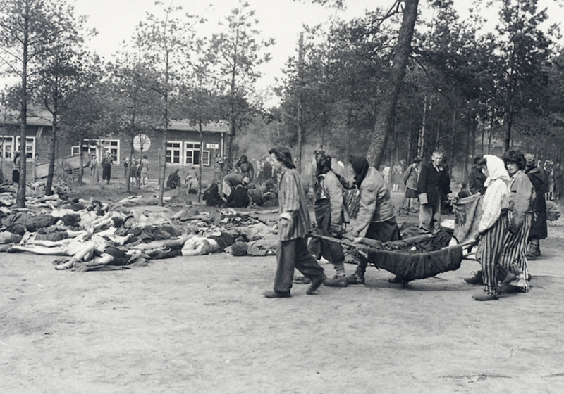 Bergen-Belsen: Häftlinge tragen die Toten aus den Baracken (Foto: PD H. L. Clyn Hughes)