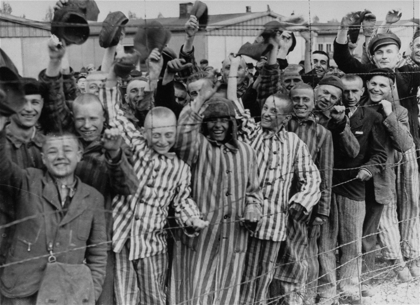 1945: Amerikanische Truppen befreien das KZ Dachau nordwestlich von München. Das Bild wurde am Tag der Befreiuung aufgenommen. Das KZ war kurz nach der Machtergreifung Hitlers im Jahr 1933 errichtet worden. Es war bis Kriegsende, also zwölf Jahre lang, ununterbrochen in Betrieb. Insgesamt waren in Dachau über 200’000 Menschen inhaftiert, 41’500 starben. Als die amerikanische Truppen das KZ befreien, befinden sich noch 32'000 Häflinge im Lager. In einem Eisenbahnwagen, der neben dem Lager steht, stossen die…