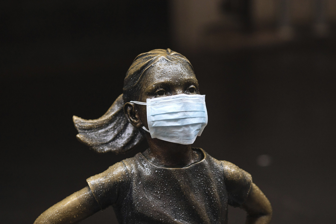 Auch das „furchtlose Mädchen“ trägt jetzt eine Schutzmaske. Die Bronzestatue „The Fearless Girl“, die von der amerikanischen Bildhauerin Kristen Visbal vor drei Jahren geschaffen wurde, steht in der Broad Street gegenüber der New Yorker Stock Exchange (NYSE, Wall Street). (Foto: Keystone/AP/Kevin Hagen)