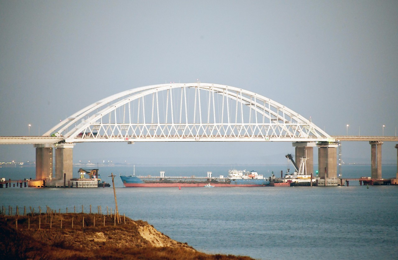 Ein russisches Schiff blockiert am 25. November den Durchgang unter der neuen Brücke, die bei der Meerenge von Kertsch das russische Festland mit der Krim verbindet und den Zugang zum Asowschen Meer beherrscht. (Foto: Keystone/AP Photo) 

