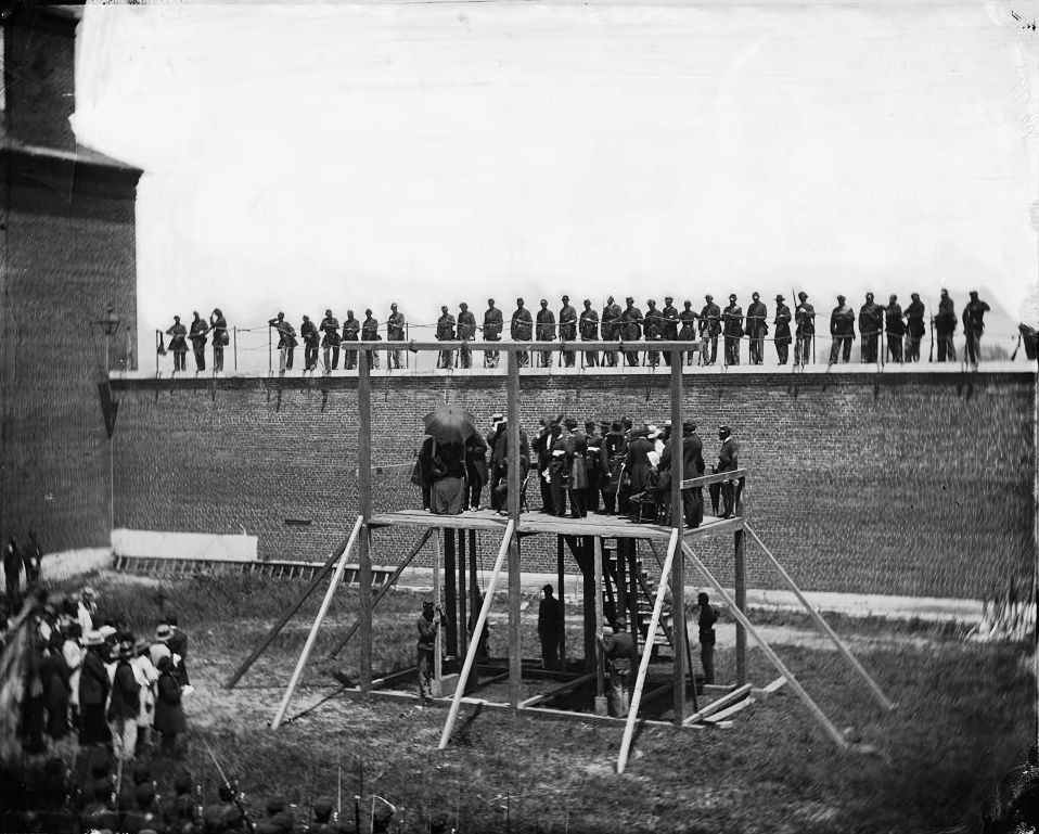 Vor der Exekution. Mary Surratt, Lewis Powell, David Herold und George Atzerodtund warten auf die Hinrichtung. Das Bild wurde am 7. Juli 1865  von Alexander Gardner aufgenommen. Gardner gehört zu den bekanntesten Fotografen des Bürgerkrieges.