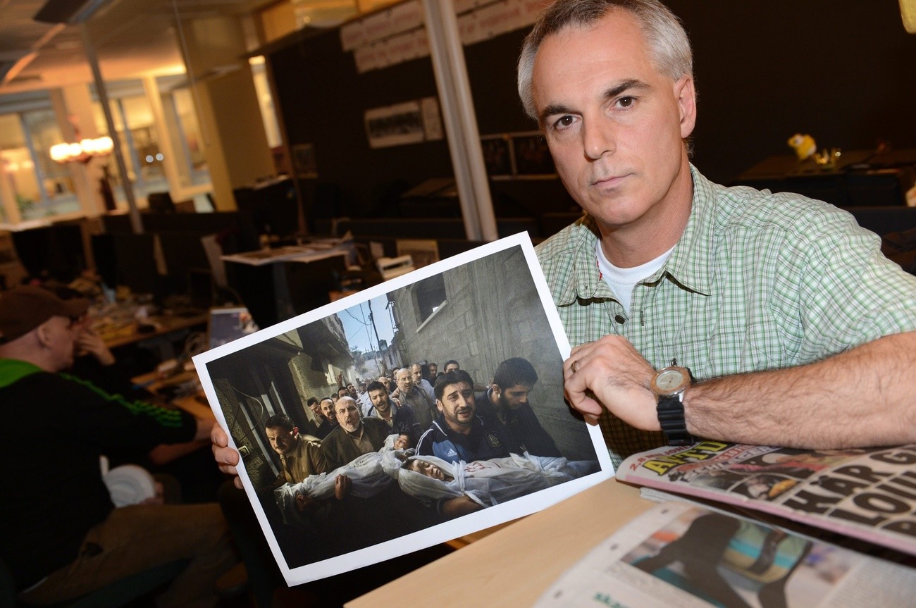 Paul Hansen of Sweden, a photographer working for the Swedish daily Dagens Nyheter holds his winning picture as he poses for photographs at the Dagens Nyheter office in Stockholm, Sweden, 15 February 2013. Hansen has won the World Press Photo of the Year 2012 with this picture of a group of men carrying the bodies of two dead children through a street in Gaza City taken on 20 November 2012. EPA/FREDRIK SANDBERG SWEDEN OUT 
