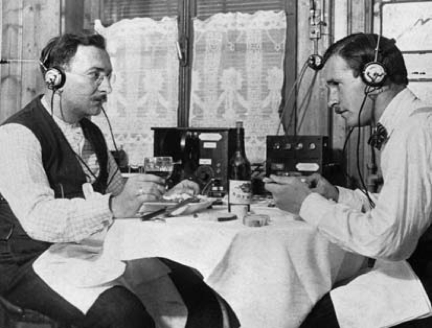 Radiohören 1920: Radiosendungen werden über Kopfhörer gehört: Die Sendequalität und die Lautstärke lassen oft zu wünschen übrig; die Empfangsgerätdetektoren müssen daher häufig nachreguliert werden. (Bild: SRG)