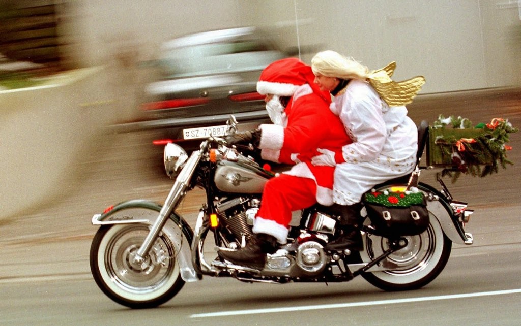 Der eilige heilige St. Nikolaus mit Engel donnert bereits am Samstag, 4. Dezember 1999, auf seinem schweren Motorrad mit erfreulich leichter Begleitung durch Zürich, damit kein Kind leer ausgeht. (Foto: Keystone/Walter Bieri)