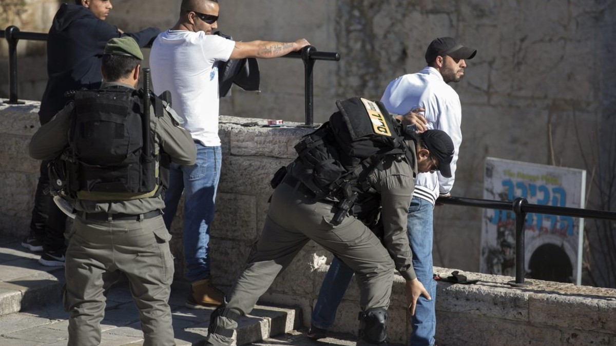 Israelische Sicherheitskräfte durchsuchen junge Palästinenser beim Damaskus-Tor in Ostjerusalem. Israel hat seine Sicherheitsmassnahmen verstärkt, nachdem am Mittwoch drei israelische Polizistinnen von Palästinensern mit Messern angegriffen worden waren. Eine Polizistin erlag ihren Verletzungen. (Foto: Keystone/EPA/Jim Hollander)
