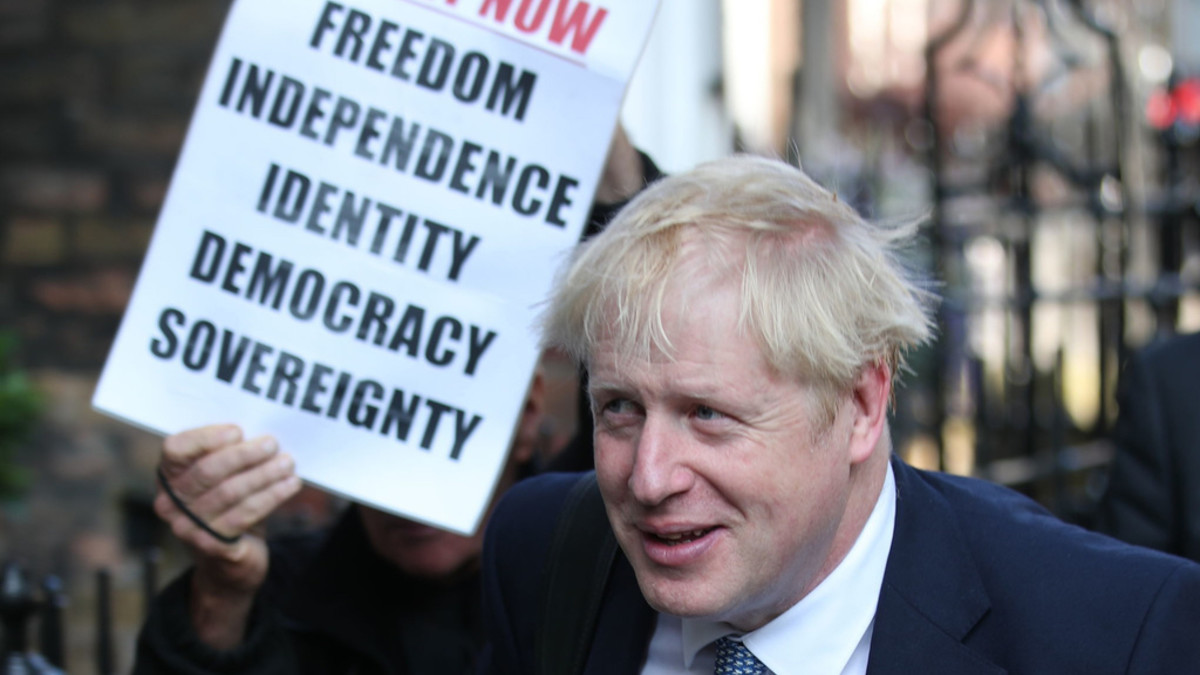 Boris Johnson entscheidet die Urwahl der Konservativen für den Parteivorsitz für sich. Bei der Ankunft bei seinem Büro steht er im Schatten des Plakats eines Brexit-Befürworters. (Keystone/PA via AP, Yui Mok)