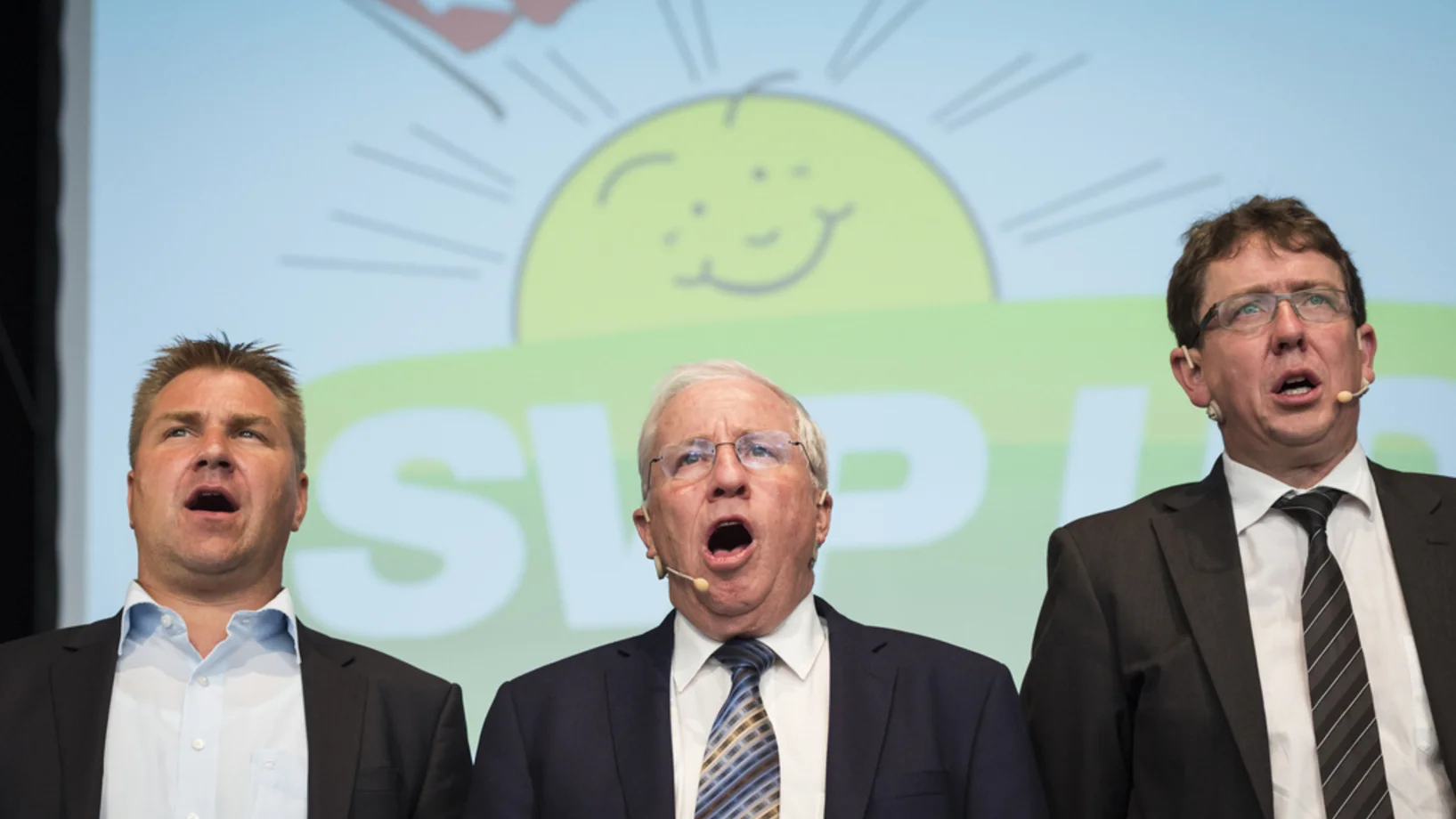 Von links: der abtretende Parteipräsident Toni Brunner, Vizepräsident Christoph Blocher und der wahrscheinlich neue Parteipräsident Albert Rösti. Das Archivbild stammt von der SVP-Delegiertenversammlung am 22. August 2015 in St. Luziensteig, Maienfeld. Zum Wahlauftakt singen die drei SVP-Politiker die Nationalhymne (Foto: Keystone/Gian Ehrenzeller). 