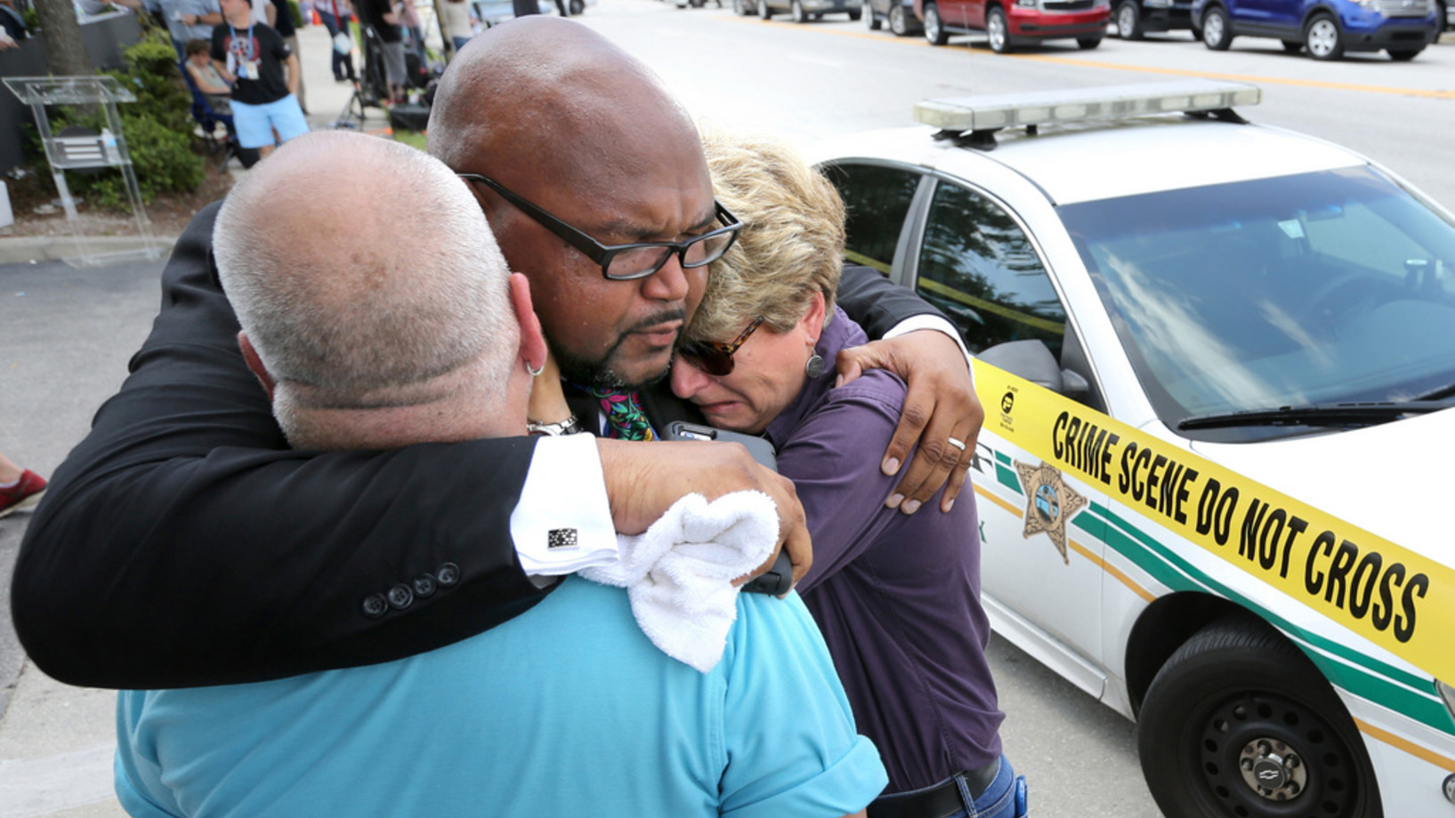 Orlandos Pfarrer Kelvin Cobaris (Mitte) tröstet Orlandos Stadtkommissarin Patty Sheehan und Terry DeCarlo, ein Gay-Rights-Anwalt bei ihrer Ankunft vor dem Ort der Schiesserei. (Foto: Keystone/Joe Burbank/Orlando Sentinel via AP)