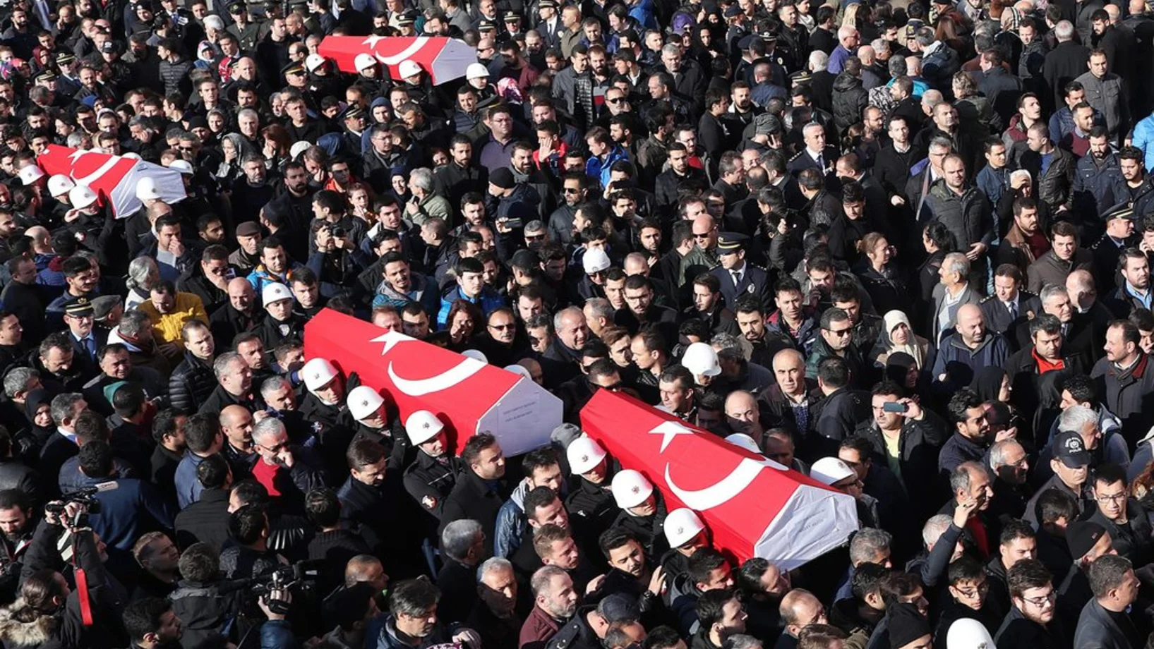 Feuerwehrleute und Polizisten tragen am Sonntag die Särge mit ihren getöteten Kollegen durch eine Menschenmenge. (Foto: Keystone/EPA/Sedat)
