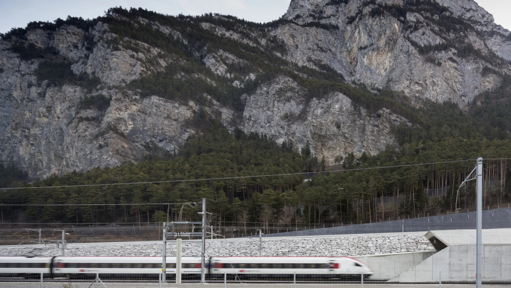 Sonntagmorgen: Ein Personenzug der SBB fährt bei Erstfeld ins Nordportal des Gotthard-Basistunnels, der eben für den regulären Verkehr freigegebenen worden ist. (Foto: Keystone/Gaetan Bally)
