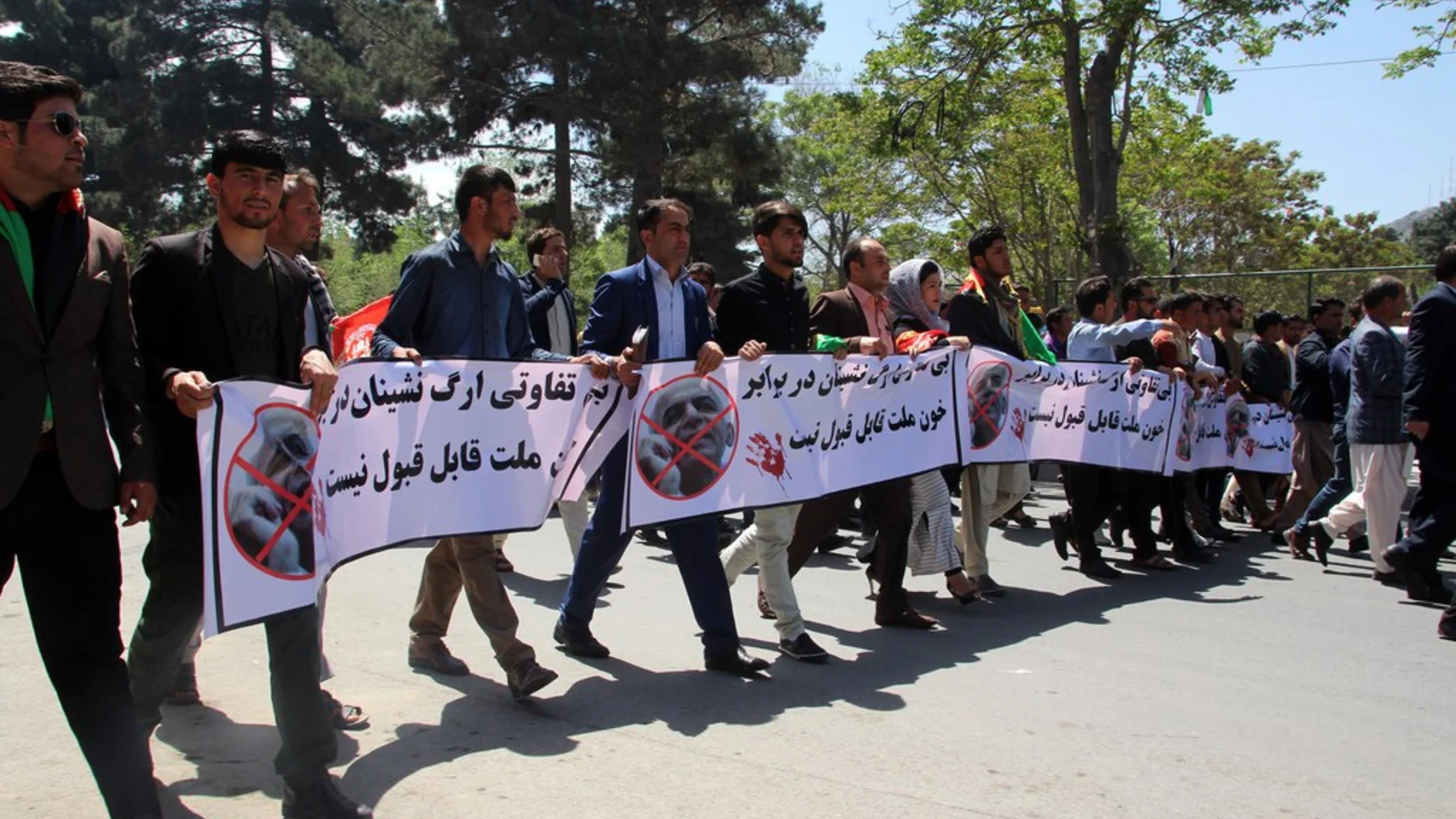 Afghanen halten Banner mit Aufschriften in Dari, einer im Land gesprochenen Sprache:  „Wir verurteilen die teilnahmslose Haltung des Präsidenten gegenüber dem Blutvergiessen.“ Den Protestierenden geht es um die weit über hundert Opfer des Anschlags, den die Taliban am 21. April auf ein Armeelager verübten. (Foto: Keystone/EPA, Jawed Kargar)  
