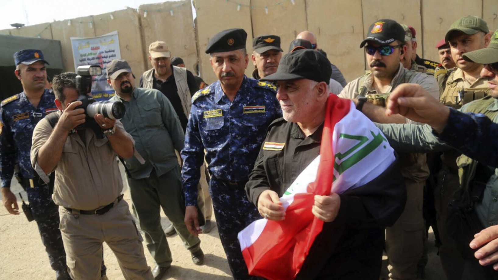 Der irakische Ministerpräsident mit einer irakischen Flagge am Sonntag in Mosul (Foto: Keystone/Iraqi Federal Police Press Office/AP) 