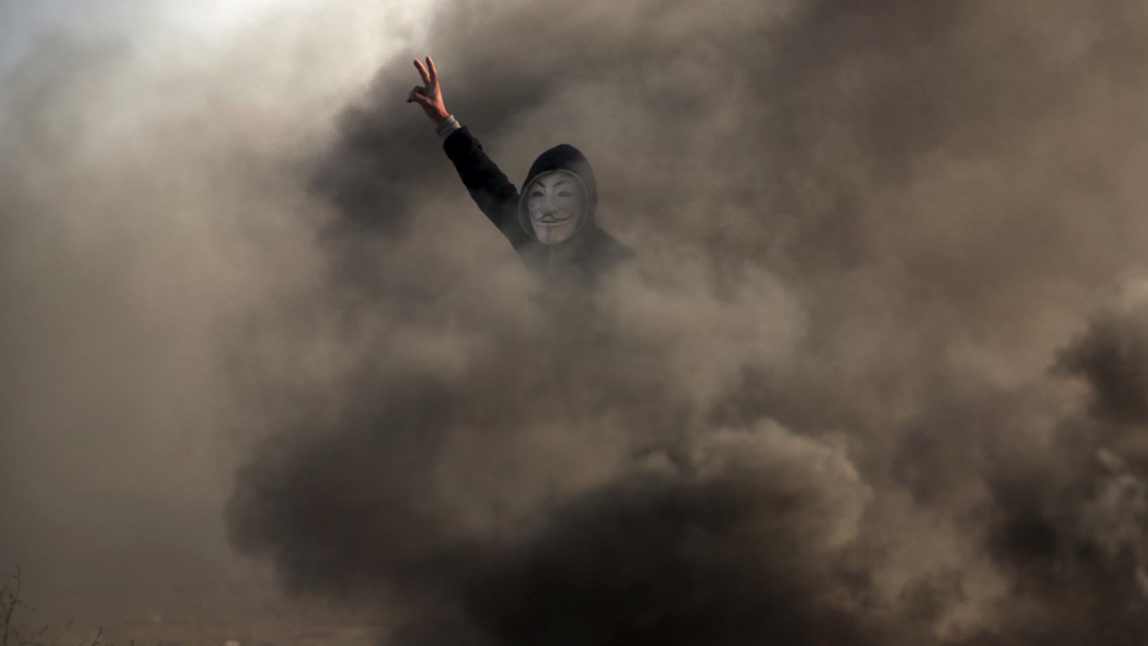 Ein palästinensischer Demonstrant mit dem V-Siegeszeichen an der Grenze zwischen dem Gaza-Streifen und Israel. (Foto: Keystone/AP/Khalil Hamra)