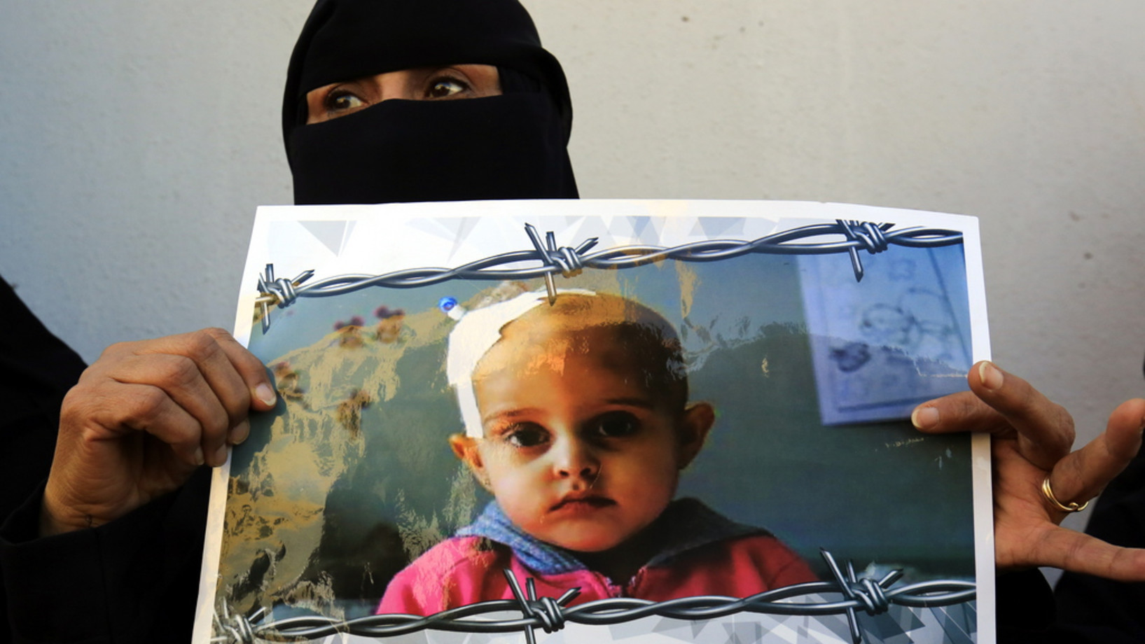 Eine jemenitische Frau hält ein Plakat bei einer Antikriegs-Kundgebung bei den Uno-Büros in Sana'a, an der Hunderte teilgenommen haben sollen. Sie verlangten mit Blick auf die Verhandlungen von Stockholm ein Ende des seit mehr als dreieinhalb Jahren andauernden Kriegs. (Keystone/EPA, Yahya Arhab)