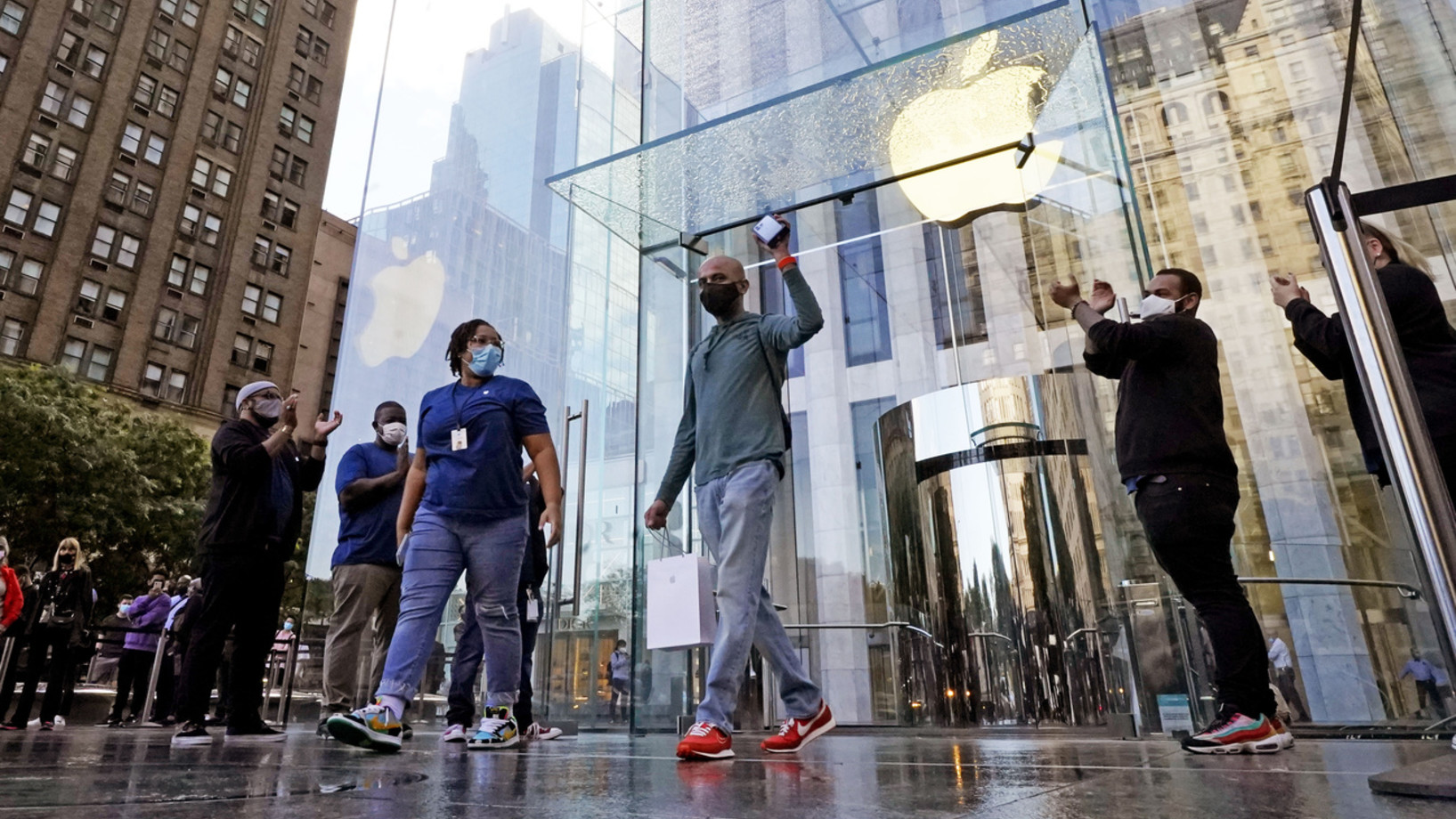 Der erste Kunde am ersten Verkaufstag hält vor dem Apple Flagship Store an der Fifth Avenue in New York triumphierend sein iPhone 13 in die Höhe. (Bild vom 24. September 2021, Keystone/AP Photo, Richard Drew)