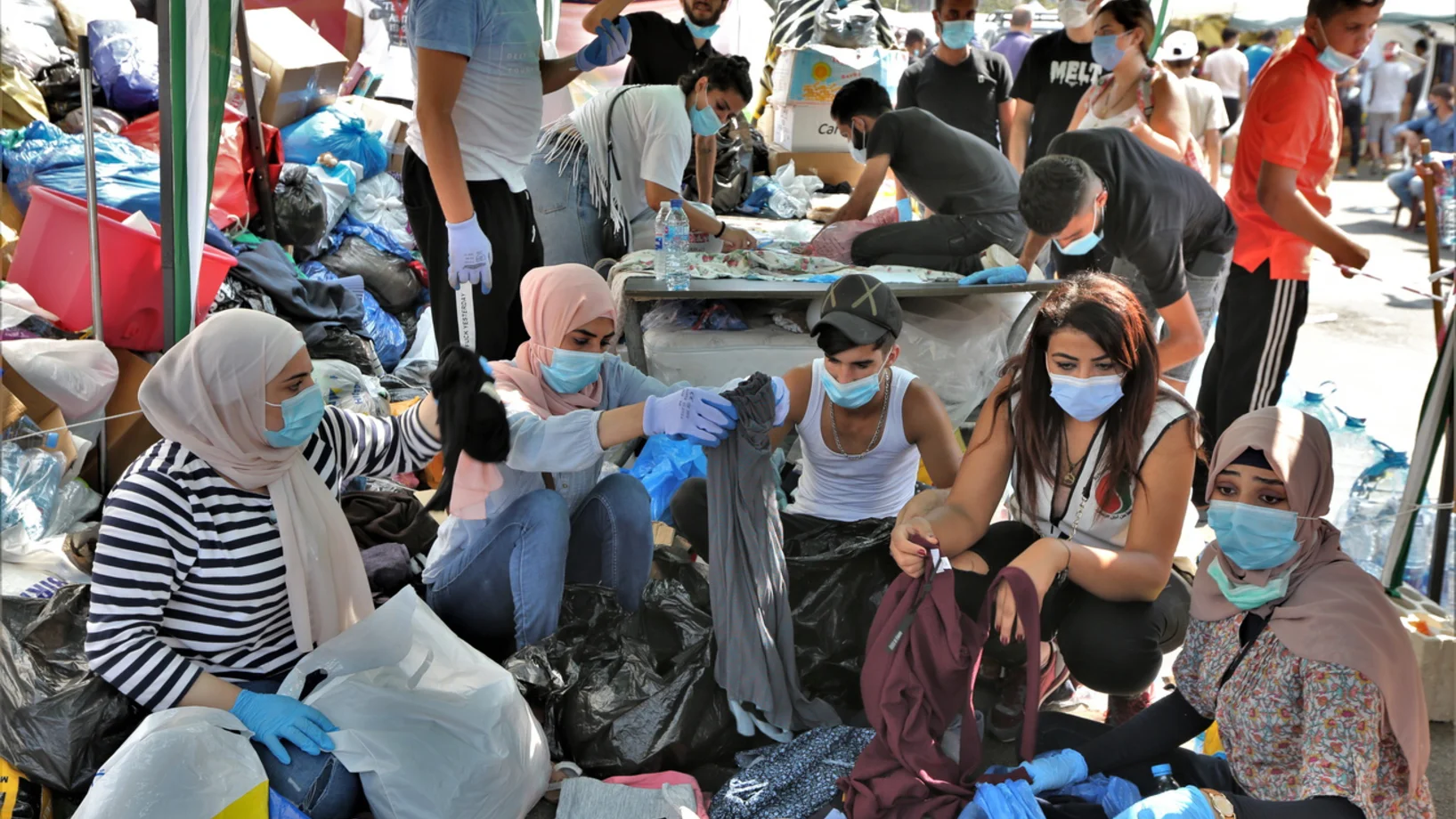 Beirut am 7. August 2020: Freiwillige bringen Familien, deren Häuser durch die Explosion am 4. August zerstört wurden, auf dem Märtyrerplatz im Zentrum Beiruts Lebensmittel und Hilfsgüter. Das libanesische Gesundheitsministerium spricht von mindestens 154 Getöteten und über 5'000 Verletzten. Noch immer wird unter den Trümmern nach Toten gesucht. (Keystone/EPA, Nabil Mounzer)