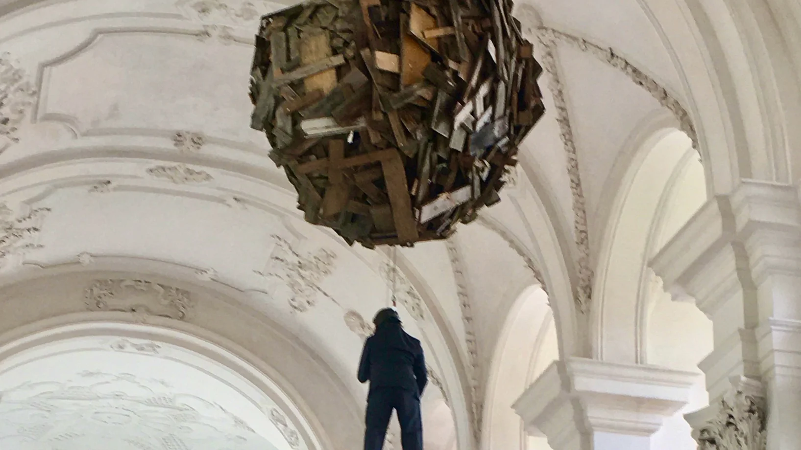 Performance bei der Eröffnung: Christoph Rütimann lässt sich zur Kugel aus Abfallholz hochziehen, in der er sich anschliessend einigeln wird.