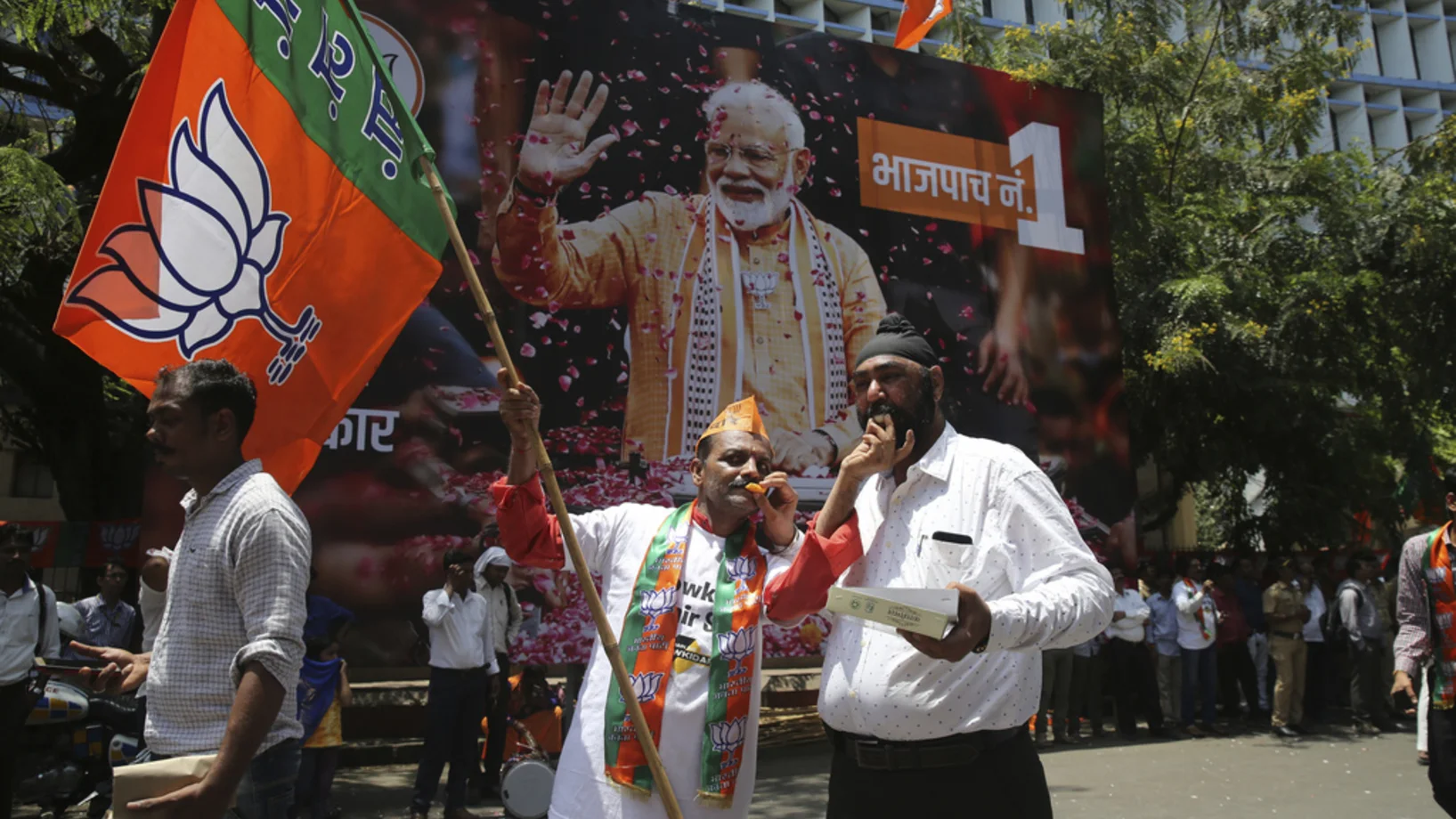 Anhänger von Modis BJP feiern am Donnerstag in Mumbai den Triumpf ihrer Partei. Im Hintergrund ein überlebensgrosses Plakat des Premierministers. (Foto: Keystone/AP/Rafiq Maqbool) 